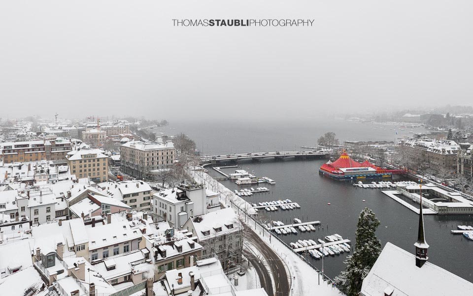 trüber verschneiter Wintertag über Zürich mit Blick auf die Quaibrücke mit Bauschänzli