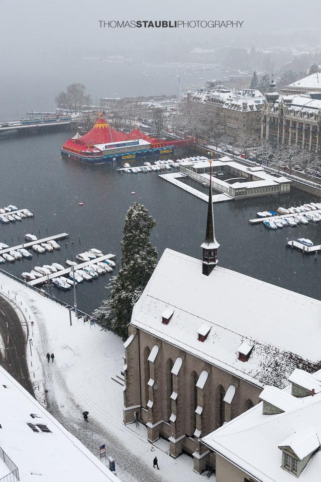 trüber verschneiter Wintertag über Zürich mit Blick auf das rote Zirkuszelt auf dem Bauschänzli