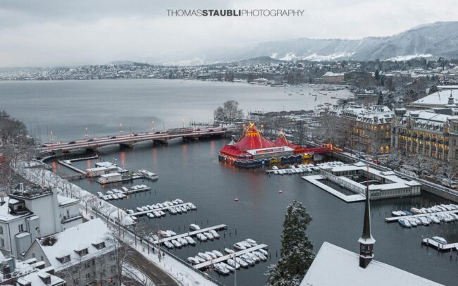 trüber verschneiter Wintertag über Zürich mit Blick auf das rote Zirkuszelt auf dem Bauschänzli