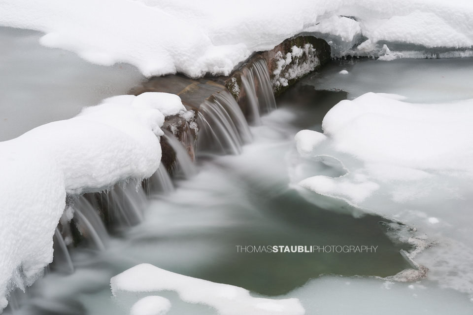 Schnee und Eis in einem Bach