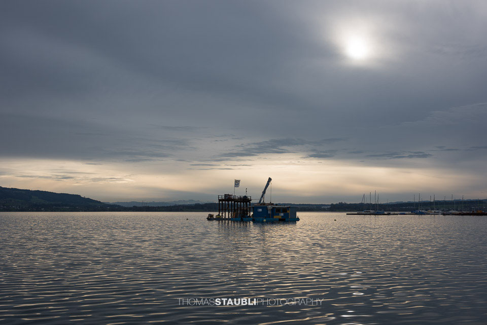 die Abendsonne durchdringt den bewölkten Himmel am Zugersee