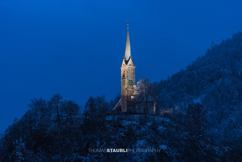 verschneite und beleuchtete Reformierte Kirche in Tamins