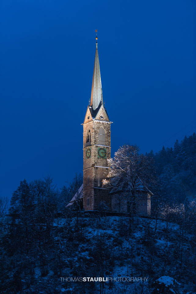 verschneite und beleuchtete Reformierte Kirche in Tamins
