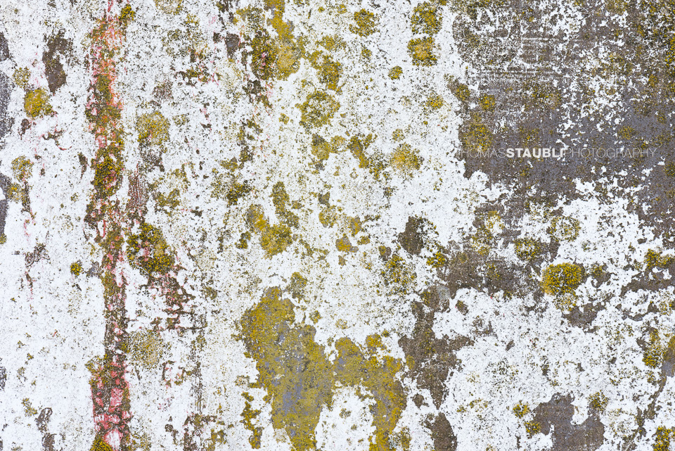 verwitterte und abblätternde Farbe an Betonwand