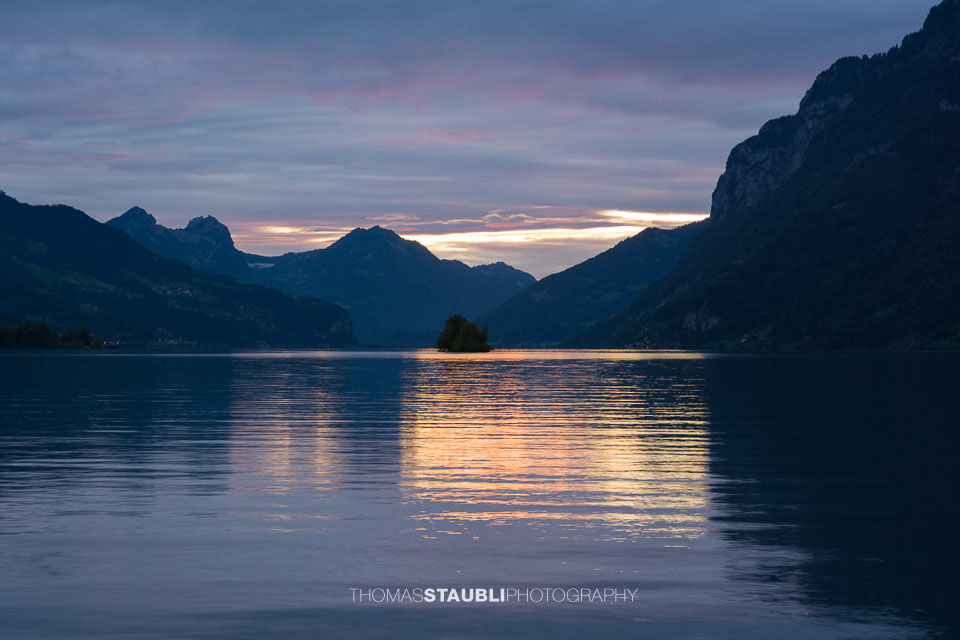 die letzten Sonnenstrahlen durchdringen den abendlichen Wolkenhimmel über dem Walensee