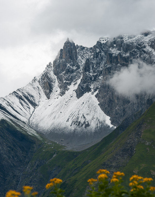 Wolkenverhangenes und weiss gezuckertes Zwölfihorn der Glarner Alpen