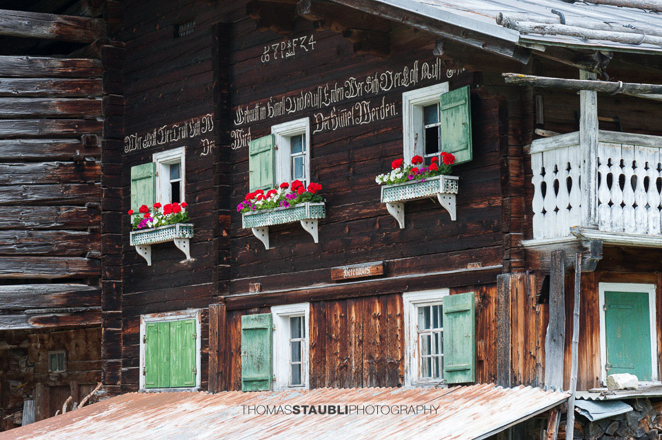 Holzfassade eines blumengeschmücktes Bauernhaus bei St. Antönien im Prättigau