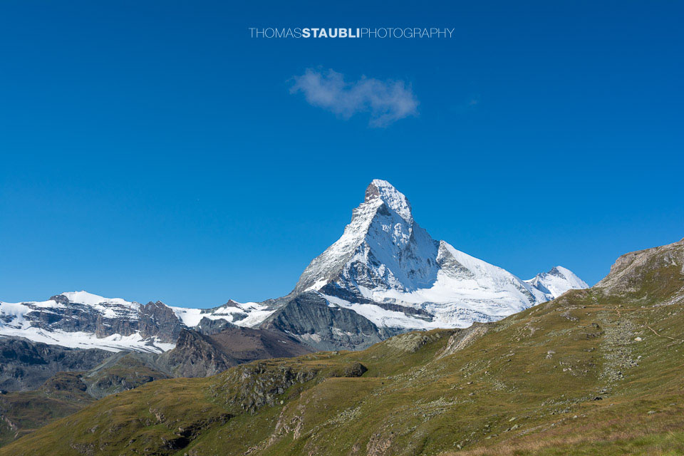 auf dem Edelweissweg Höhbalmen mit Blick auf das verschneite Matterhorn vor wolkenlosem blauem Himmel
