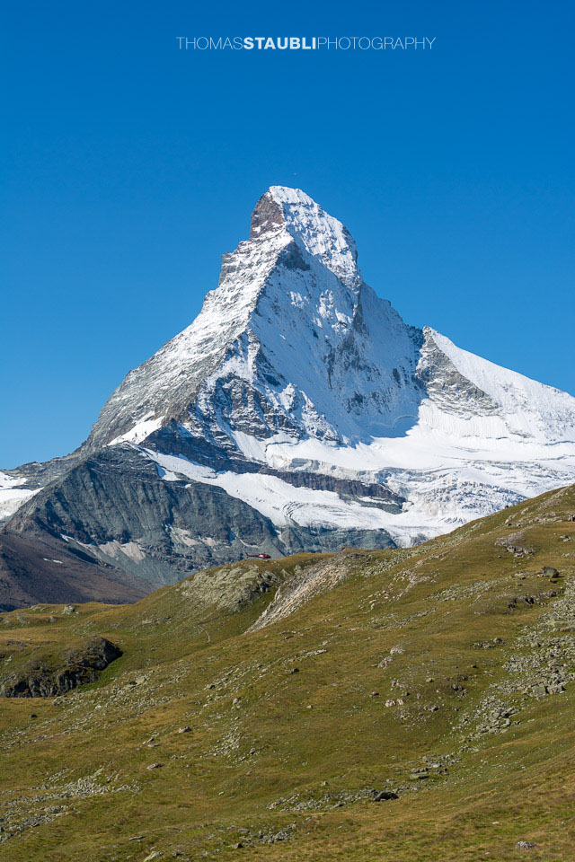 auf dem Edelweissweg Höhbalmen mit Blick auf das verschneite Matterhorn vor wolkenlosem blauem Himmel