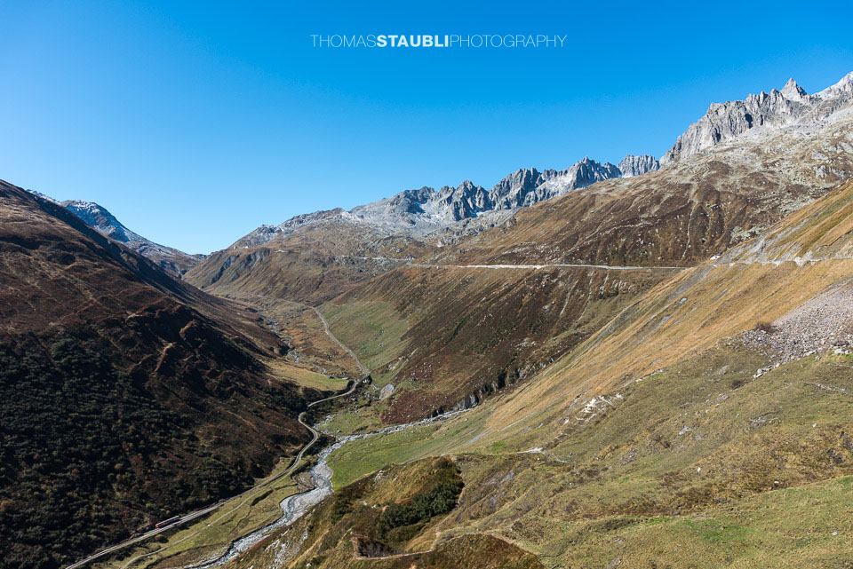 Blick hinauf zum Furkapass im Urserental, im Talgrund die Furkabahn