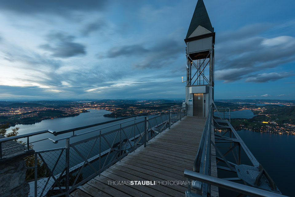 Der Hammetschwand Lift auf dem Bürgenstock, im Hintergrund die Stadt Luzern beim eindunkeln