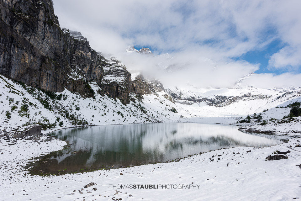 Sonne und Wolken über dem verschneiten Oberblegisee
