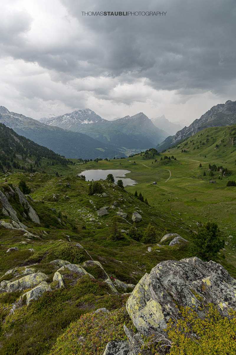 Gewitterwolken über dem Lai da Vons mit Sicht auf Pizzo Tambo und Guggernüll