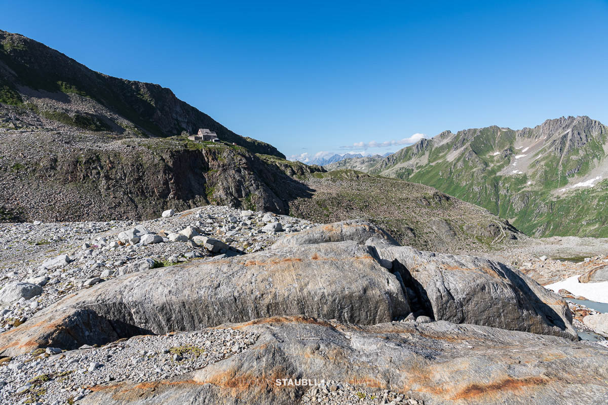 Die Rotondohütte auf einem Felsvorsprung zuhinderst im Witenwasserental