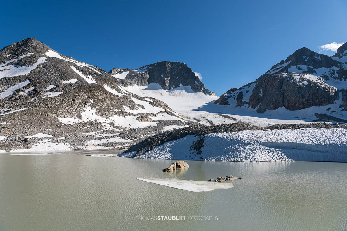 Gletschersee des Witenwasserengletschers, im Hintergrund vor blauem Himmel der Hüenerstock und Witenwasserenstock.