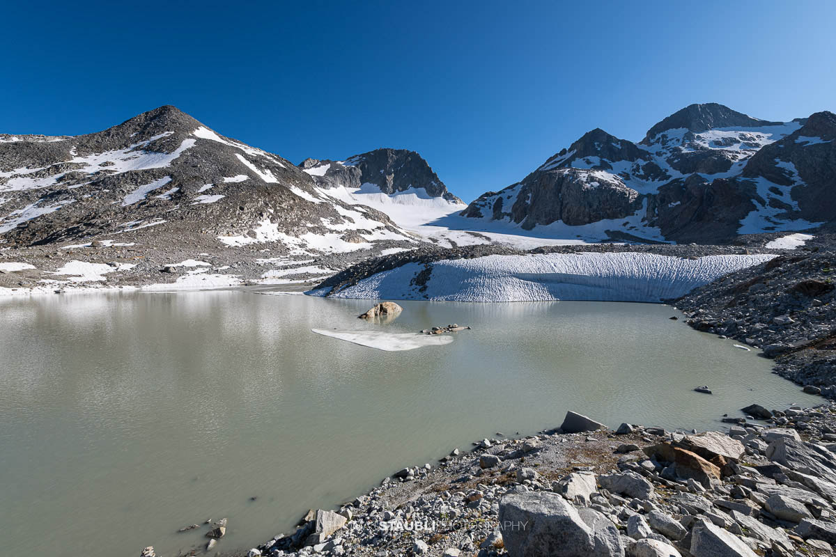 Gletschersee des Witenwasserengletschers, im Hintergrund vor blauem Himmel der Hüenerstock und Witenwasserenstock.