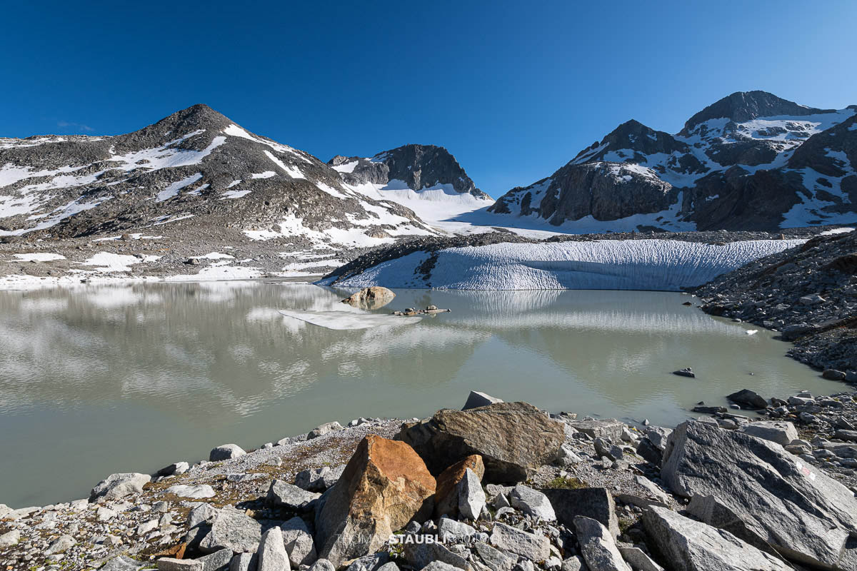 Gletschersee des Witenwasserengletschers, im Hintergrund vor blauem Himmel der Hüenerstock und Witenwasserenstock.
