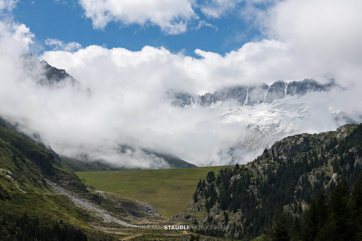 Blick von der Göscheneralp im Kanton Uri zum wolkenverhangenen Winterbergmassiv mit Gletscher und steilen Felsflanken.