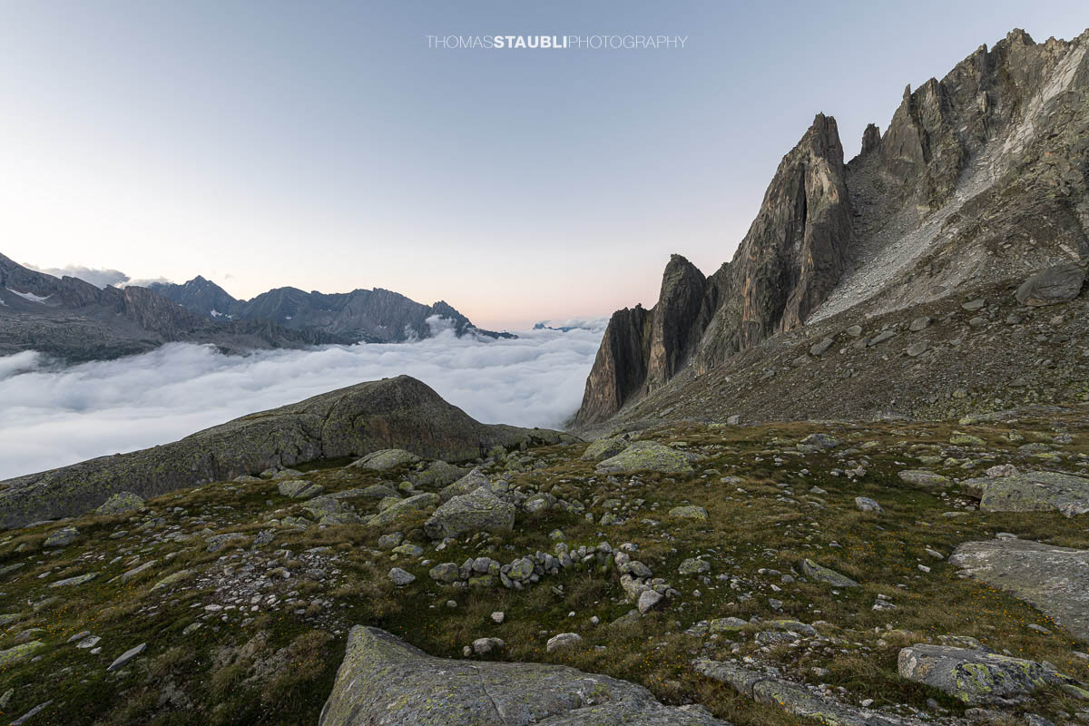 Älprigen in der Abenddämmerung mit Blick auf die Felsschijen-Gipfel und das Nebelmeer im Göschenertal.