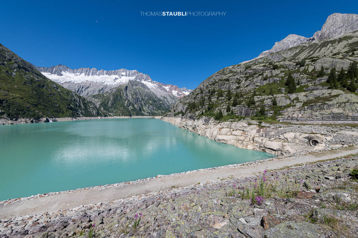 Türkisblauer Göscheneralpsee im Göschenertal, im Hintergrund das Winterbergmassiv mit dem Dammagletscher und markanten Felswänden.