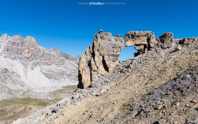 Natürliches Felsentor im Val d’Agnel im Kanton Graubünden, mit Blick auf die umliegende Bergwelt nahe der Fuorcla digl Leget.