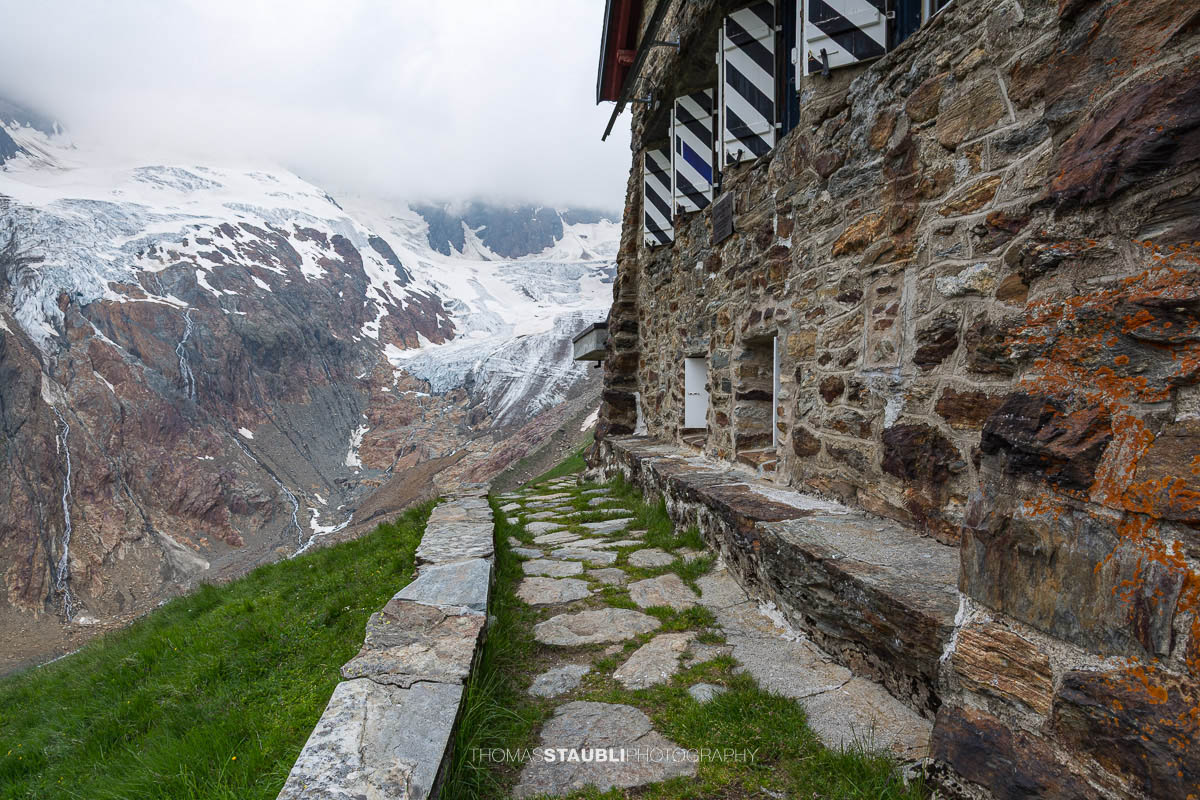 Die Chelenalphütte im Kanton Uri liegt hoch über dem Chelenreuss, mit eindrucksvollem Blick auf den Chelengletscher unterhalb des Winterbergmassivs, teils in Wolken gehüllt.