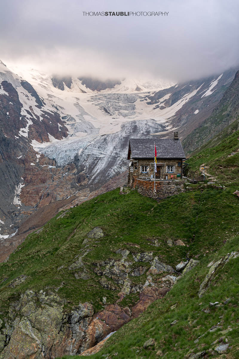 Die Chelenalphütte im Kanton Uri liegt hoch über dem Chelenreuss, mit eindrucksvollem Blick auf den Chelengletscher unterhalb des Winterbergmassivs, teils in Wolken gehüllt.