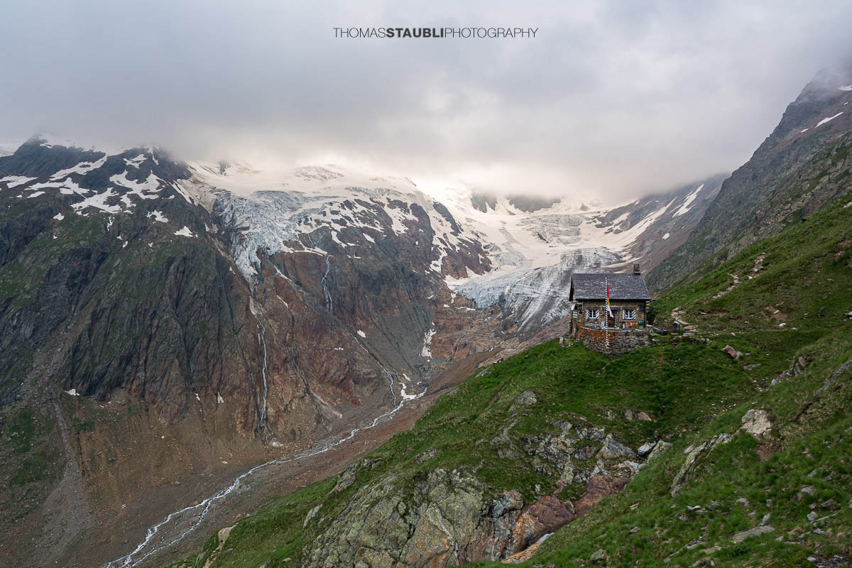 Die Chelenalphütte im Kanton Uri liegt hoch über dem Chelenreuss, mit eindrucksvollem Blick auf den Chelengletscher unterhalb des Winterbergmassivs, teils in Wolken gehüllt.