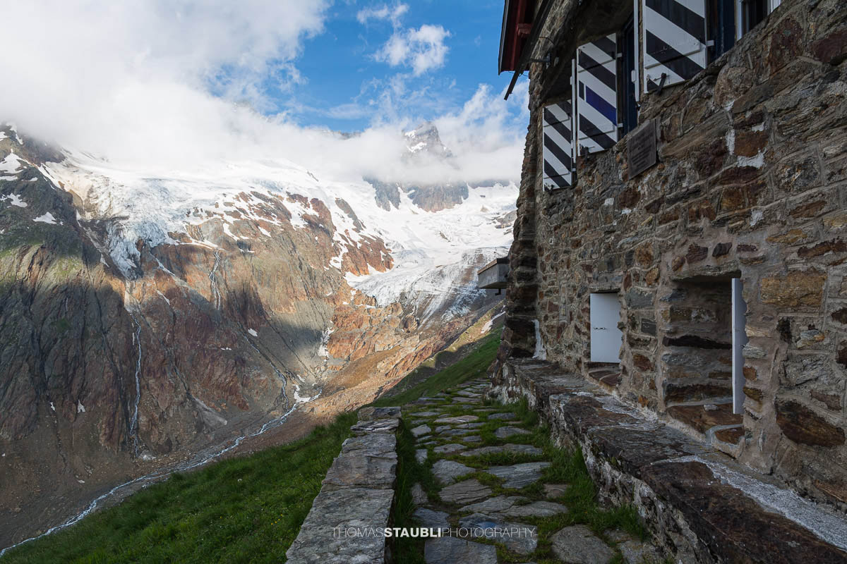 Die Chelenalphütte im Kanton Uri liegt hoch über dem Chelenreuss, mit eindrucksvollem Blick auf den Chelengletscher unterhalb des Winterbergmassivs, teils in Wolken gehüllt.