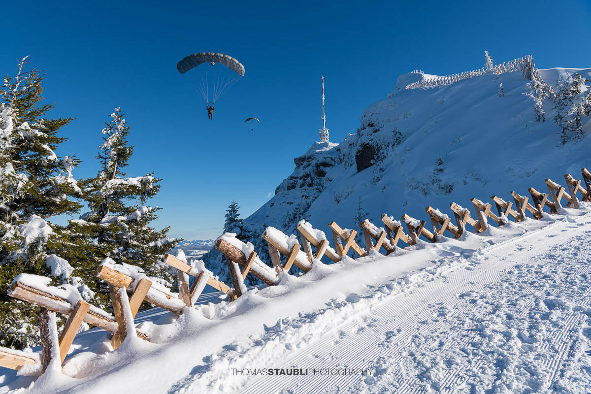 Verschneiter Rigi Kulm mit Schneezäunen, Gipfelantenne und klarem Winterhimmel in der Zentralschweiz.