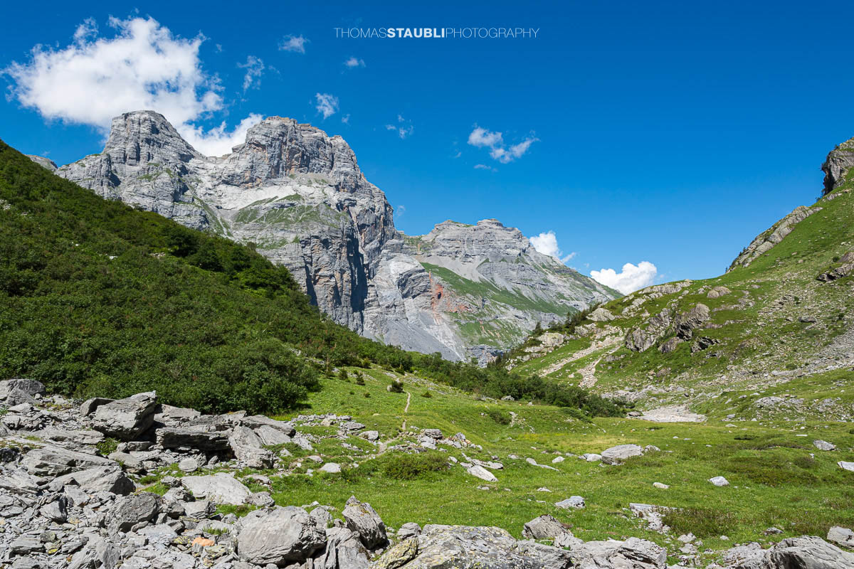 Alpines Gelände im Gebiet Tänntiwang im Kanton Glarus, mit steilen Felsflanken des Beggistock und Zuetriibistock, Geröll und Weideflächen zwischen Hinter Sand und der Fridolinshütte.