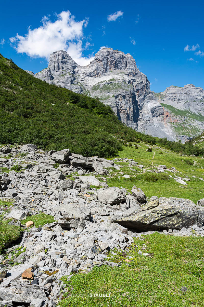 Alpines Gelände im Gebiet Tänntiwang im Kanton Glarus, mit steilen Felsflanken des Beggistock und Zuetriibistock, Geröll und Weideflächen zwischen Hinter Sand und der Fridolinshütte.