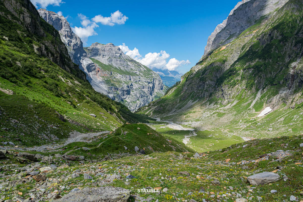 Alpines Gelände im Gebiet Tänntiwang im Kanton Glarus, mit steilen Felsflanken, Geröll und Weideflächen zwischen Hinter Sand und der Fridolinshütte.