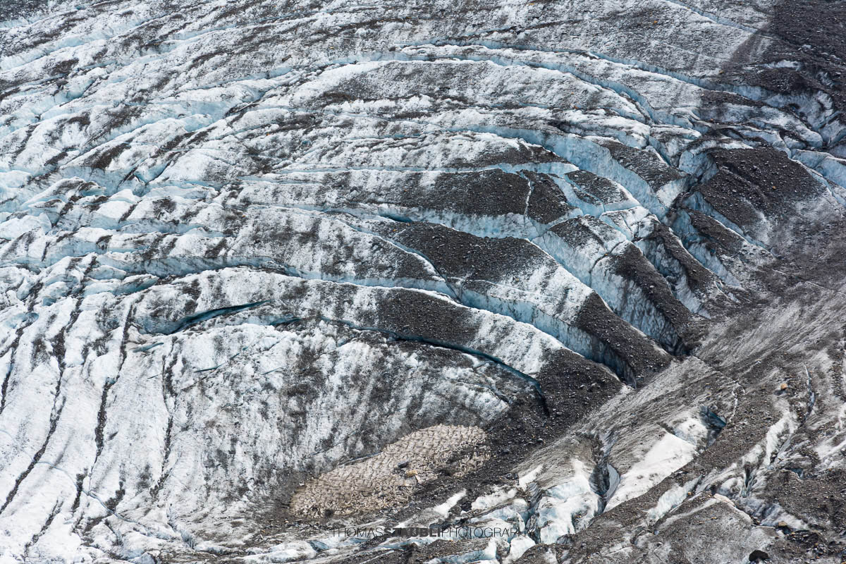 Detailansicht des Bifertenfirns im Kanton Glarus im Jahr 2013, mit zerklüftetem Eis, Firnstrukturen und dunklen Schuttzonen am Gletscherrand, eingebettet in steile Felsflanken.