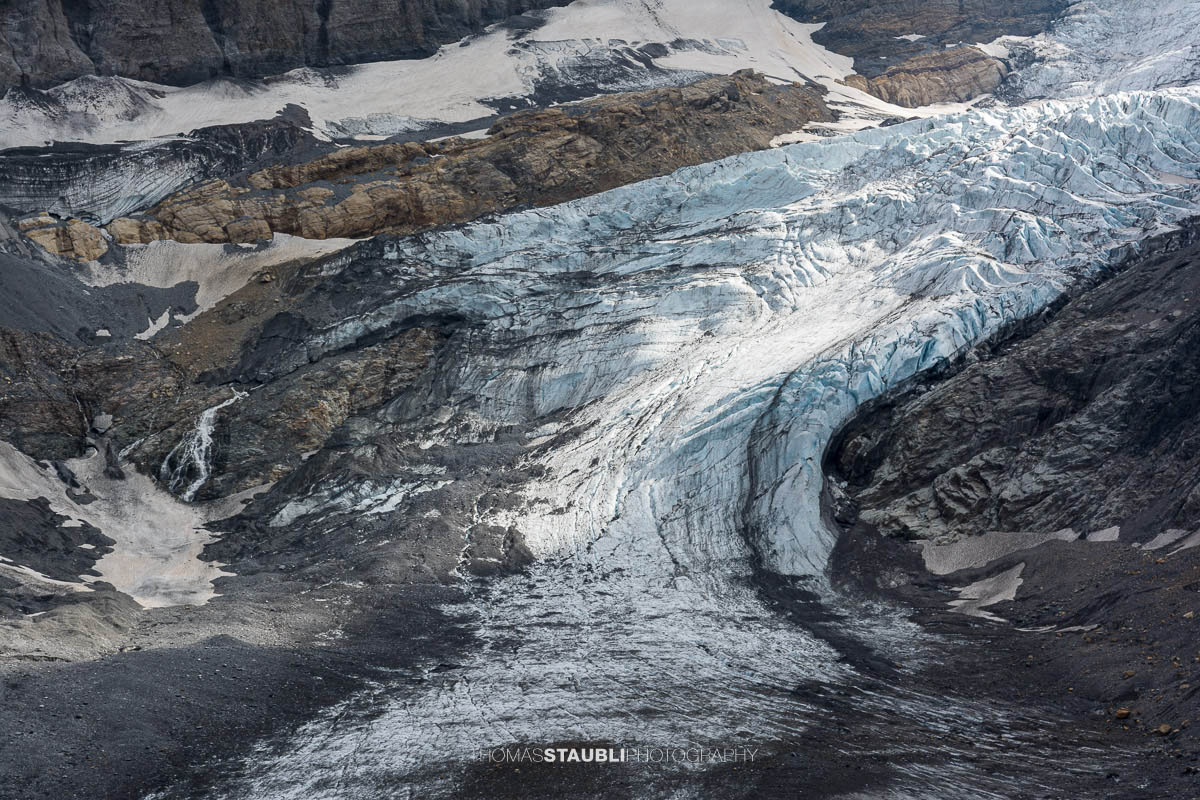 Detailansicht des Bifertenfirns im Kanton Glarus im Jahr 2013, mit zerklüftetem Eis, Firnstrukturen und dunklen Schuttzonen am Gletscherrand, eingebettet in steile Felsflanken.