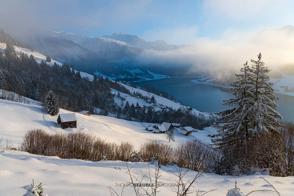 Verschneite Hügellandschaft oberhalb des Wägitalersees, im Hintergrund der Fluebrig teilweise im Nebel, Winterstimmung im Wägital, Kanton Schwyz.