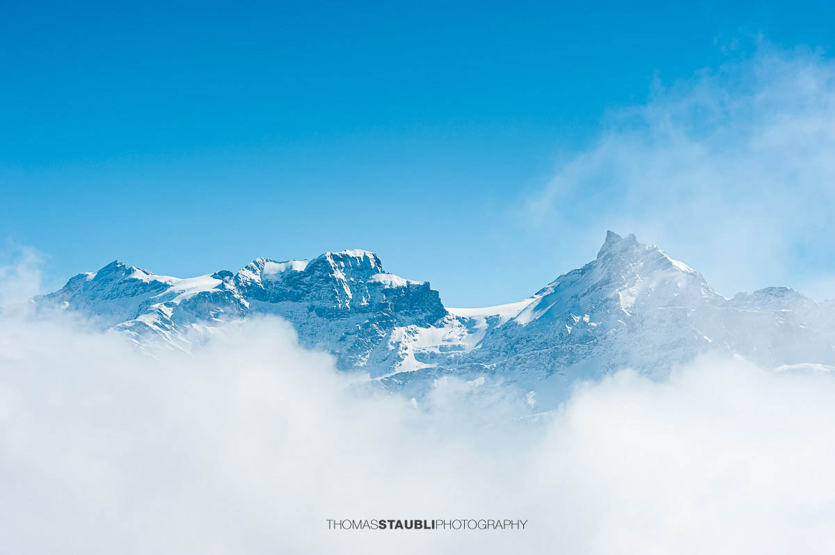 Der Chammliberg mit Gross Schärhorn und Chli Schärhorn im Winter, teilweise von Wolken umhüllt.