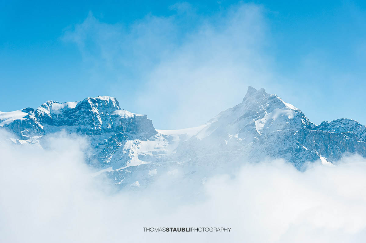 Der Chammliberg mit Gross Schärhorn und Chli Schärhorn im Winter, teilweise von Wolken umhüllt.
