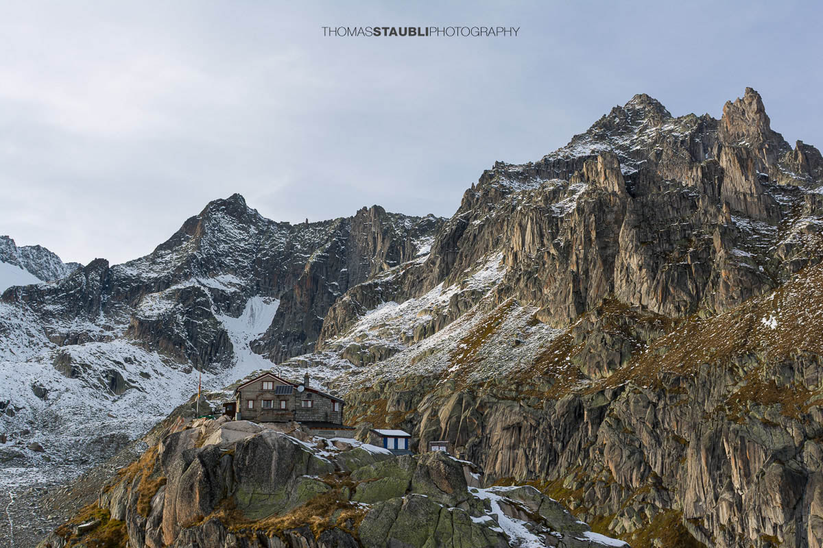 Albert-Heim-Hütte oberhalb des Urserentals, umgeben von schroffen Felswänden und ersten Schneefeldern in alpiner Hochgebirgslandschaft.