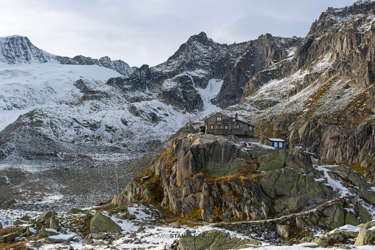 Albert-Heim-Hütte oberhalb des Urserentals, umgeben von schroffen Felswänden und ersten Schneefeldern in alpiner Hochgebirgslandschaft.