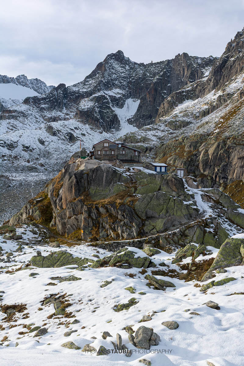 Albert-Heim-Hütte oberhalb des Urserentals, umgeben von schroffen Felswänden und ersten Schneefeldern in alpiner Hochgebirgslandschaft.