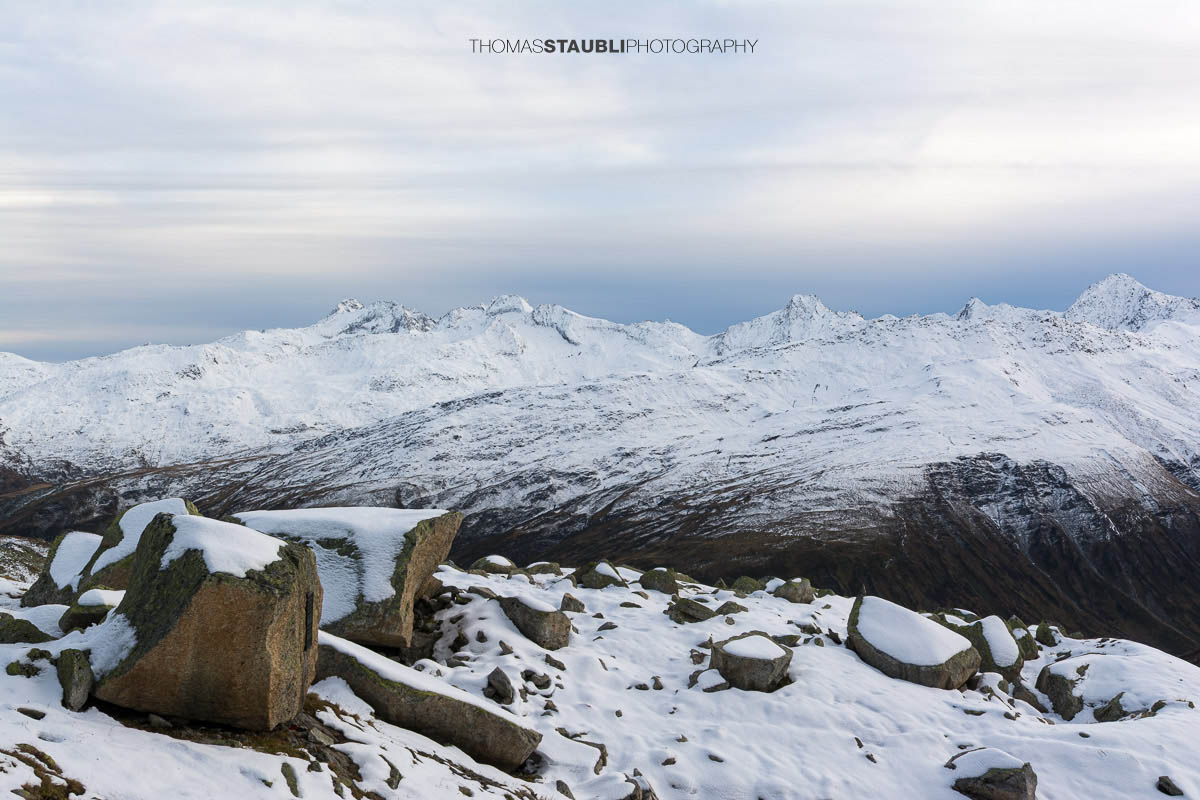 Blick ins Urserental, verschneite Gipfel und herbstlich gefärbte Hänge im Übergang zum Winter.