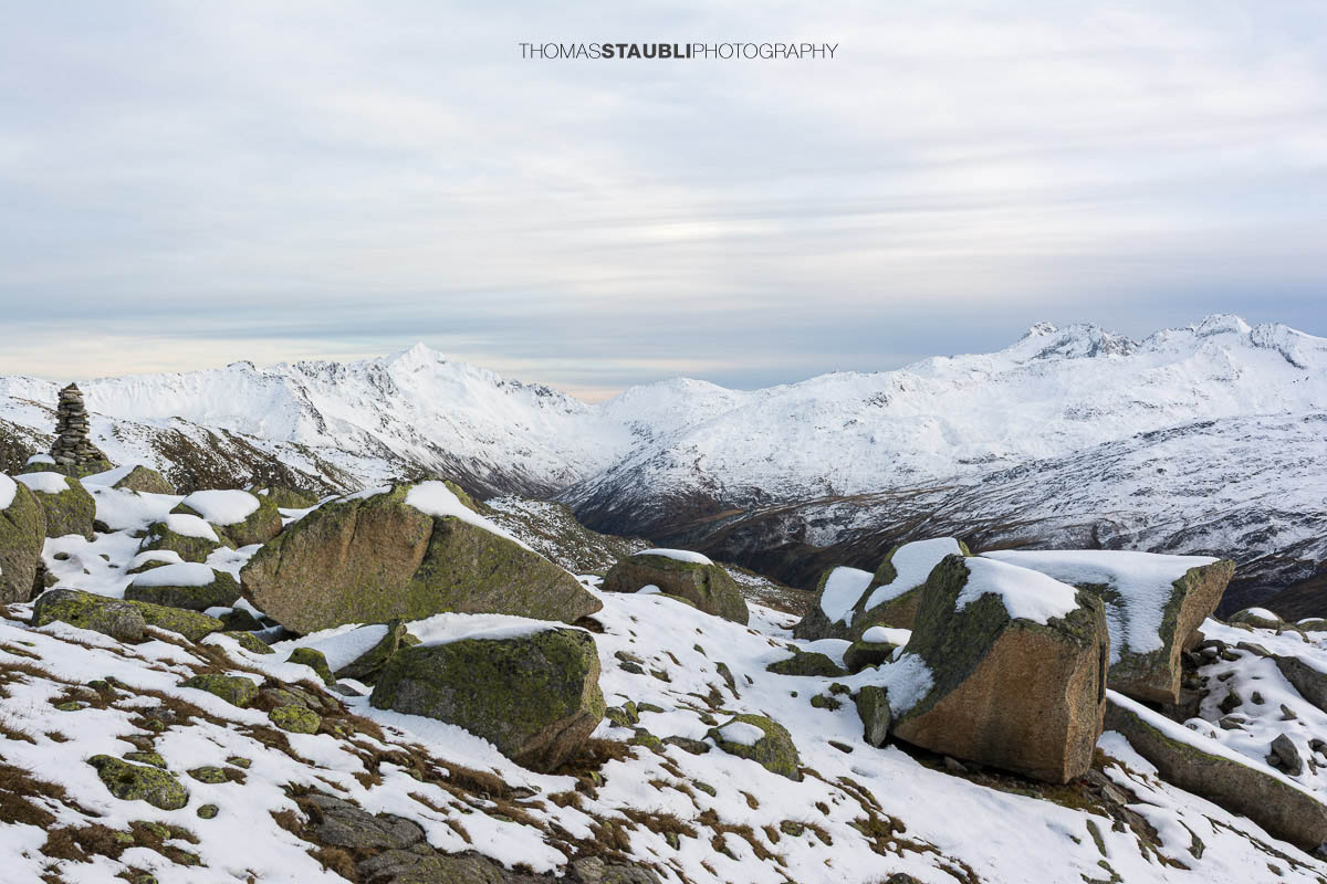 Blick ins Urserental, verschneite Gipfel und herbstlich gefärbte Hänge im Übergang zum Winter.