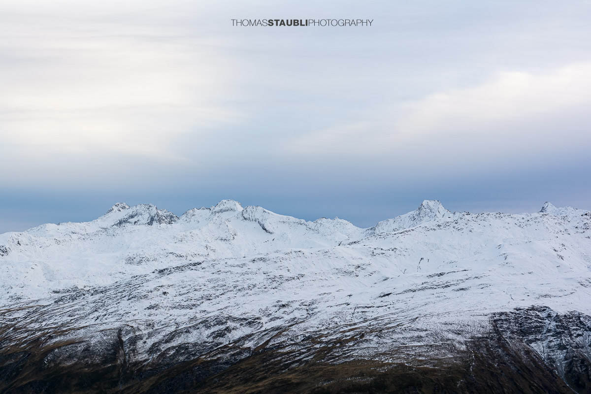 Blick ins Urserental, verschneite Gipfel und herbstlich gefärbte Hänge im Übergang zum Winter.