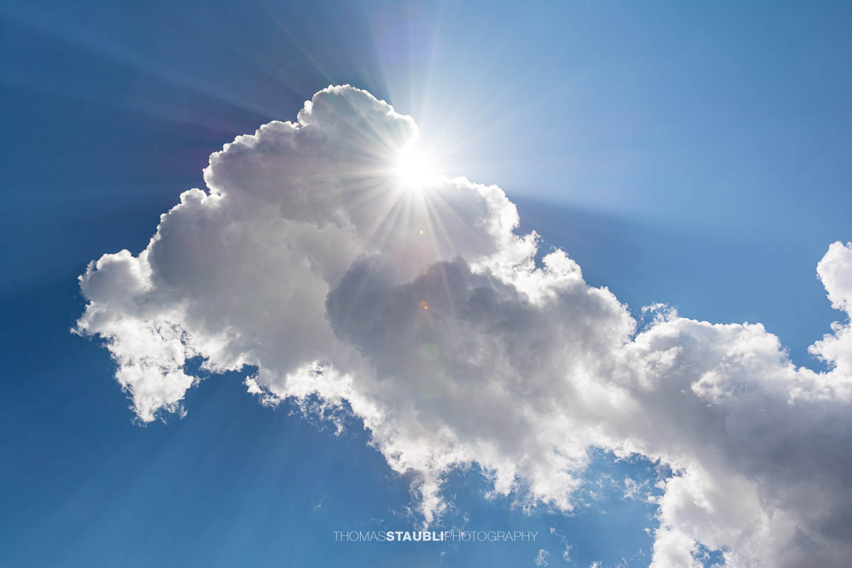 Sonne hinter Cumuluswolken