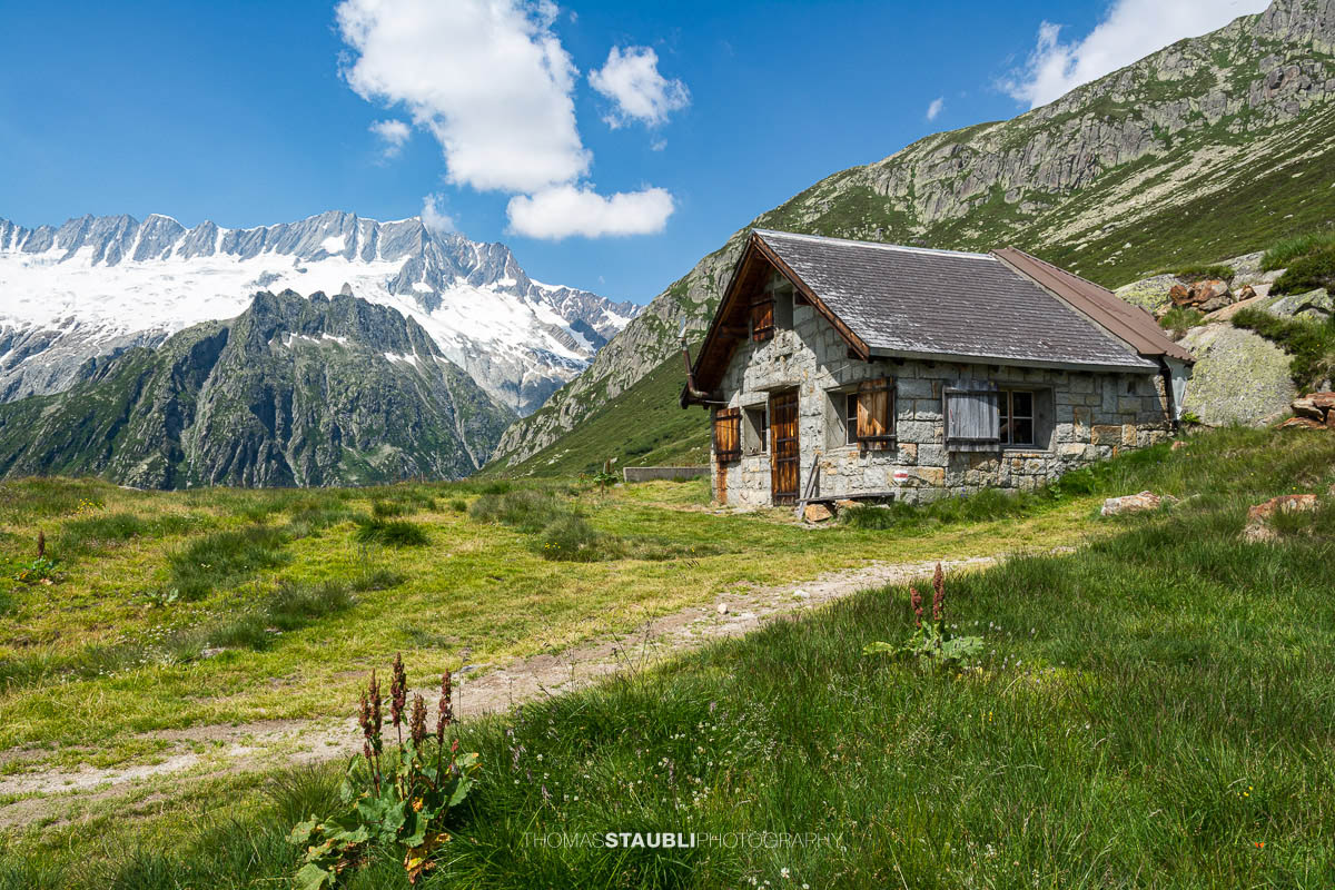 Alphütte auf der Göscheneralp unter blauem Himmel.
