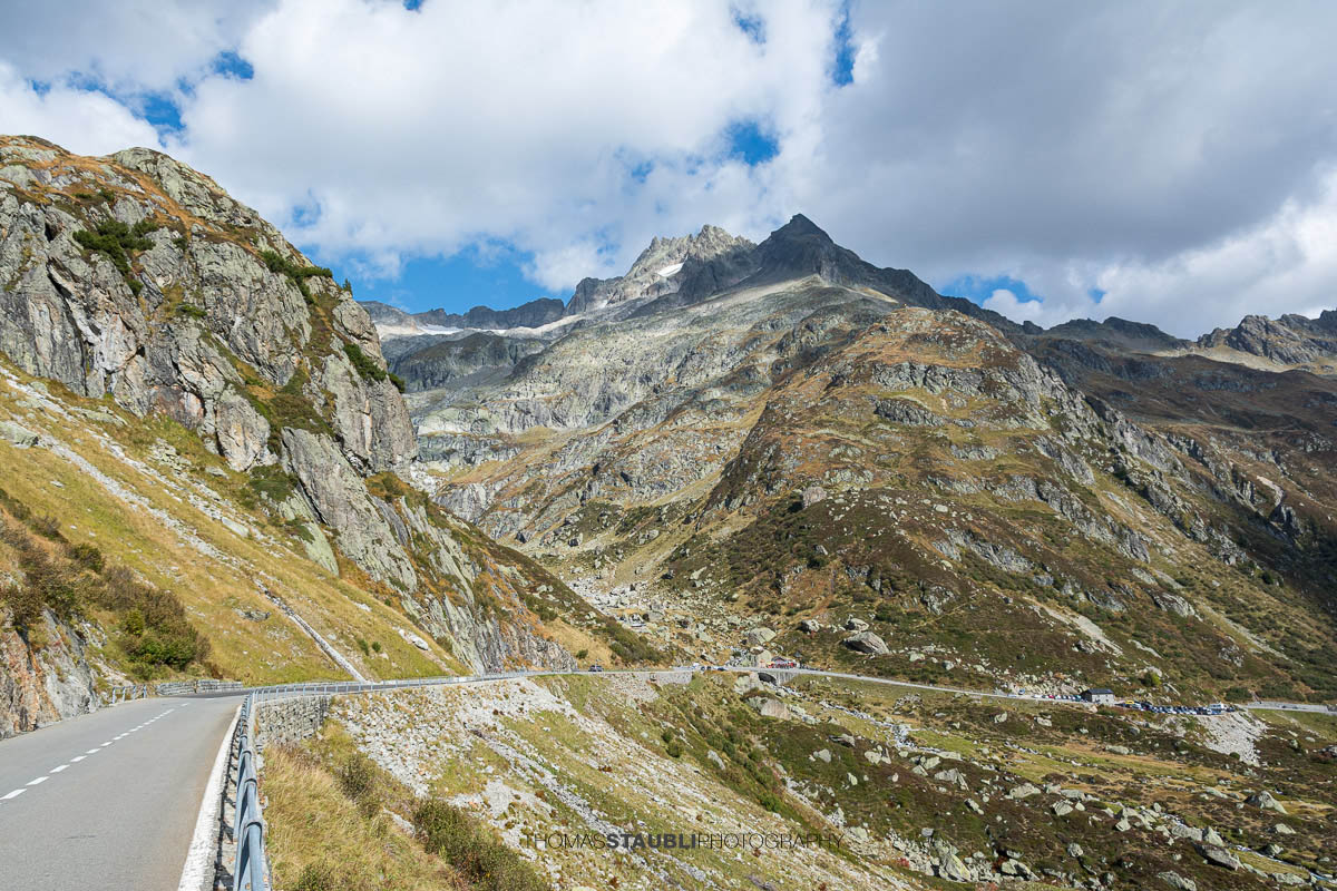 Sustenpassstrasse in den Schweizer Alpen mit kurviger Strasse, felsigen Berghängen und Blick auf das Böschenstöckli unter bewölktem Himmel.