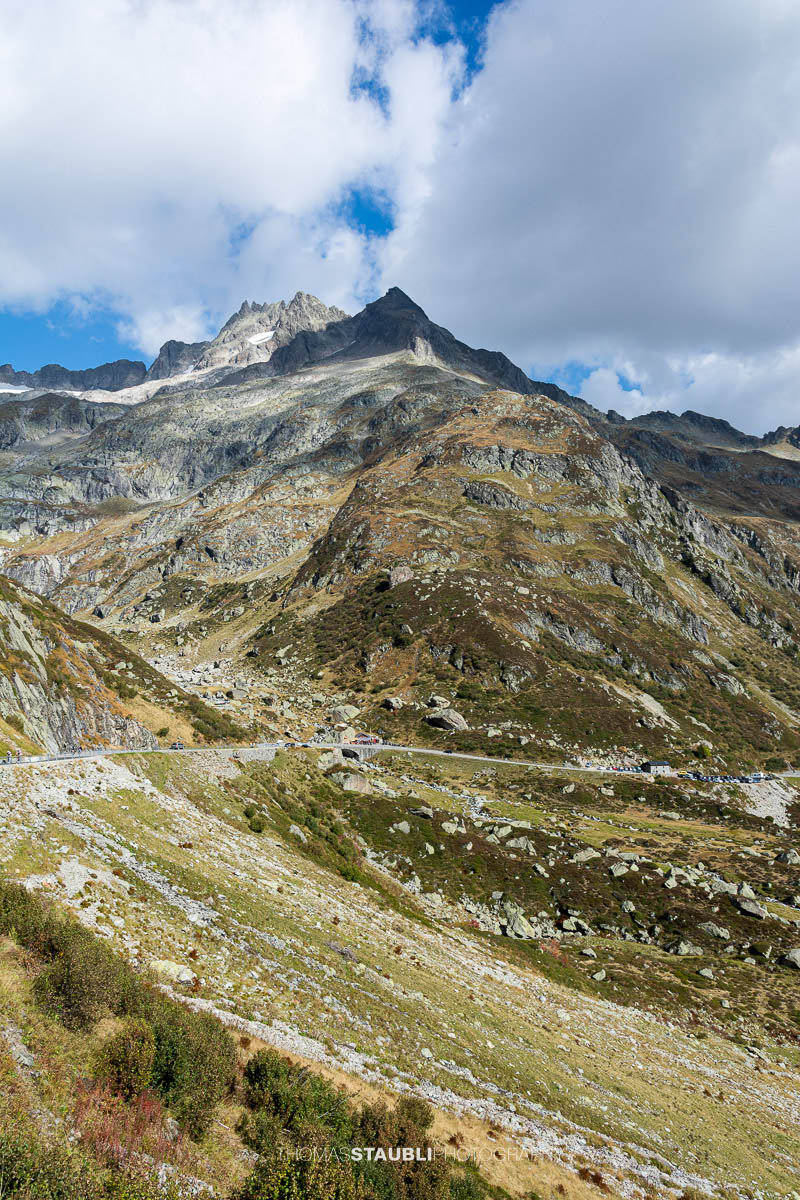 Sustenpassstrasse in den Schweizer Alpen mit kurviger Strasse, felsigen Berghängen und Blick auf das Böschenstöckli unter bewölktem Himmel.