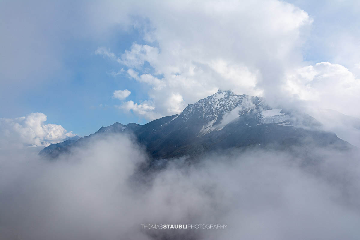 Blick zum Stucklistock in den Urner Alpen, markanter Gipfel mit Schneefeldern, teilweise von Wolken umhüllt.