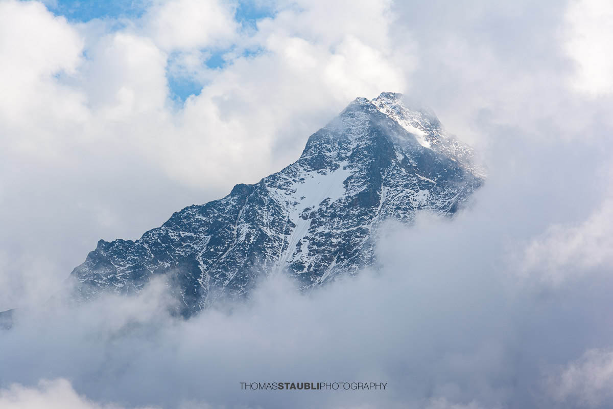 Blick zum Stucklistock in den Urner Alpen, markanter Gipfel mit Schneefeldern, teilweise von Wolken umhüllt.